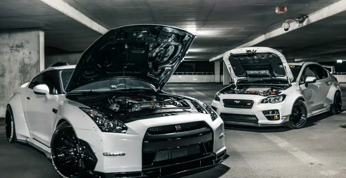 two white cars with open hoods