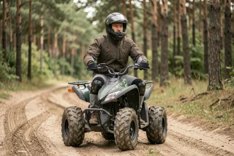 Homme adulte débutant sur un quad électrique tout-terrain en forêt avec équipement de sécurité complet